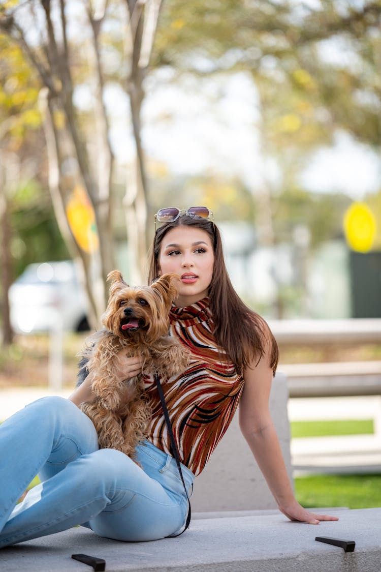 Woman With Sunglasses On Her Head Holding A Dog