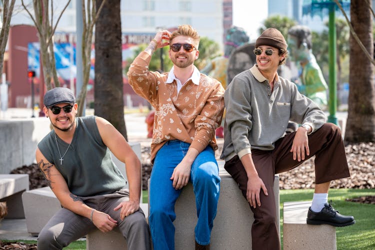 Smiling Group Of Men Sitting In A Park