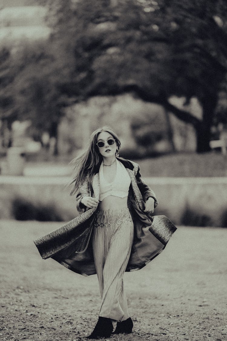 Woman Twirling In A Coat And Sunglasses