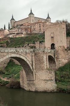 Scenic view of a historic bridge and castle in Toledo, Spain.