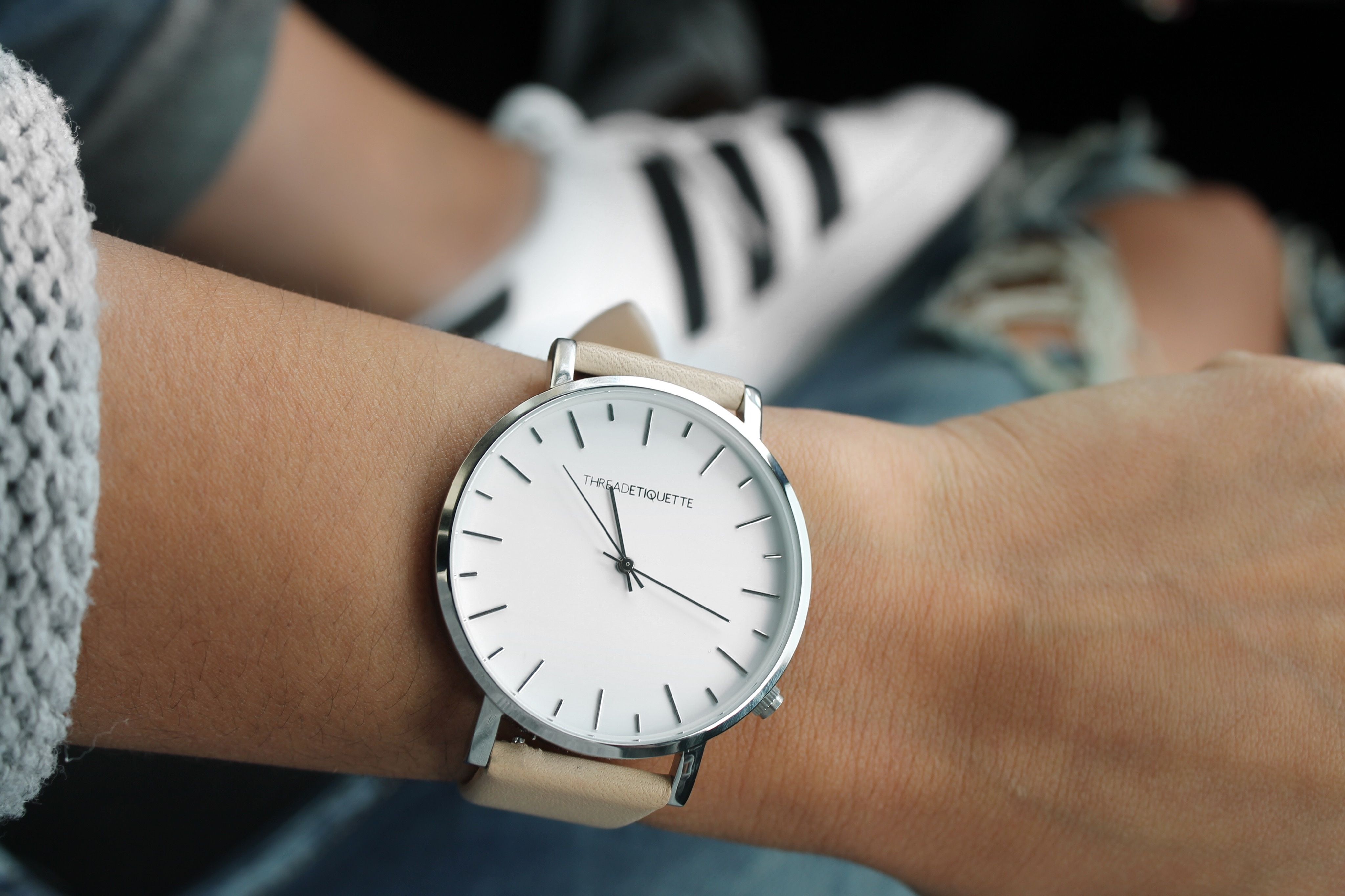 Beige Strap Silver Round Analog Watch Behind Adidas White