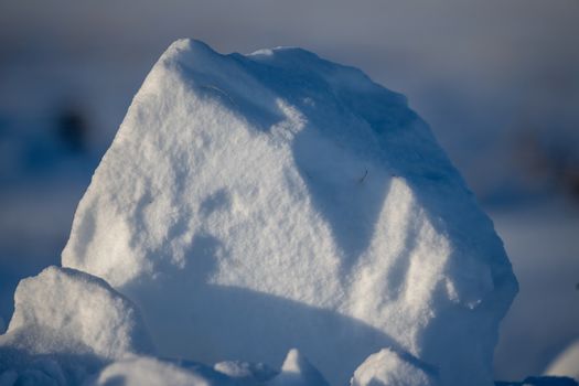 Detailed close-up photograph of a snow block, capturing the texture and light during winter in Minnesota.