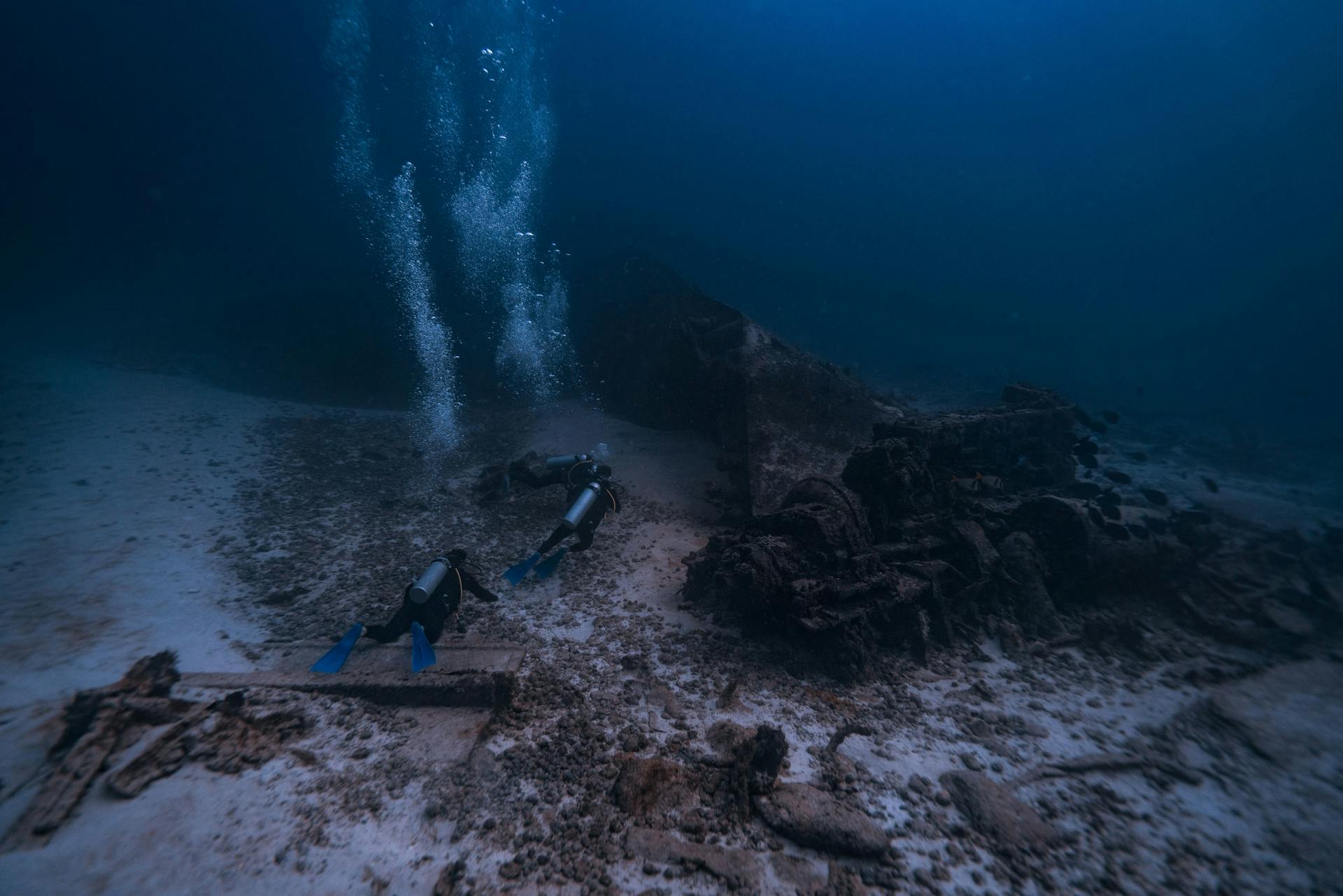 Scuba Divers Swimming near Shipwreck