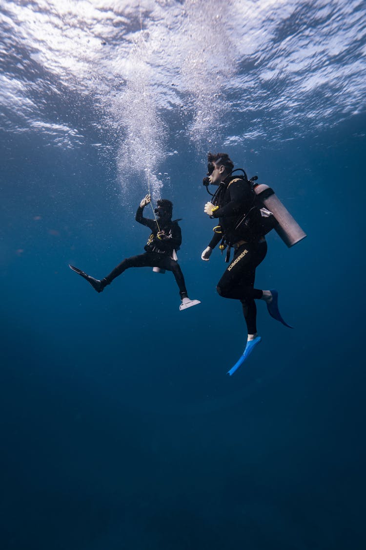 Scuba Divers With Equipment Underwater