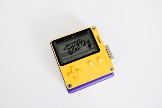 Close-up of a modern yellow handheld game console displaying 'Whitewater Wipeout' game.