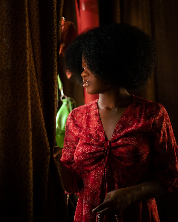 Woman In Red Dress Looking Out From Behind Curtain