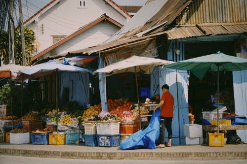 Free Busy outdoor fruit market stall with colorful produce and local vendor. Stock Photo