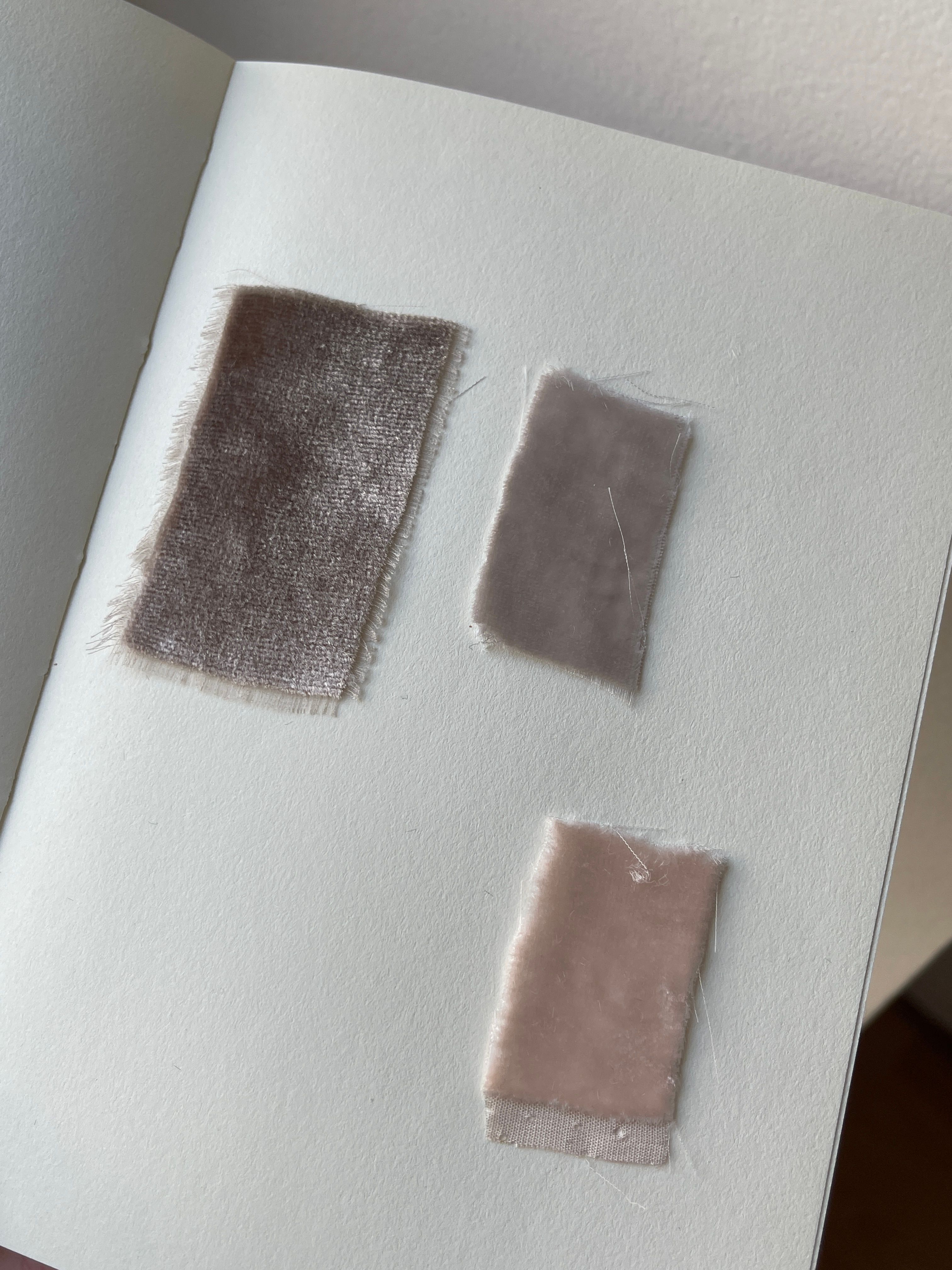 Close-up of fabric swatches on a notebook, showcasing texture and minimalist design.