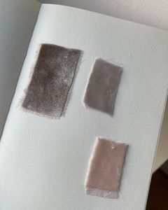 Close-up of fabric swatches on a notebook, showcasing texture and minimalist design.