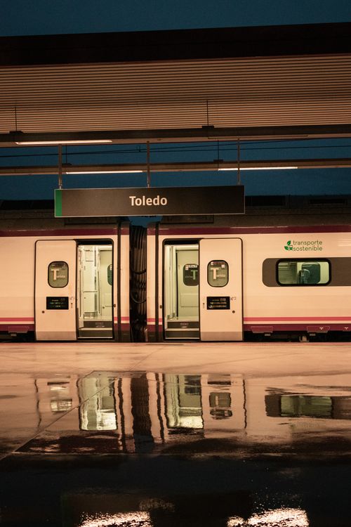 Free Toledo train station platform with train and reflections. Urban transport scene at night. Stock Photo