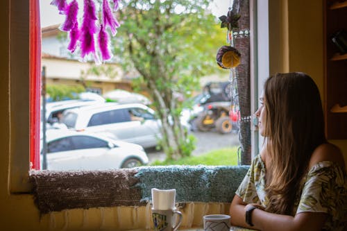 Woman Wearing Green Off-shoulder Sitting Beside Window