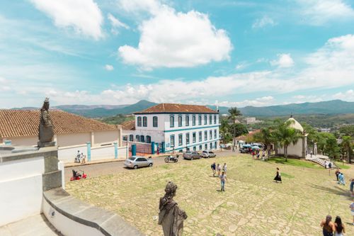 Free A sunny day in Congonhas, Brazil, showcasing a historic plaza with statues, tourists, and colonial architecture. Stock Photo