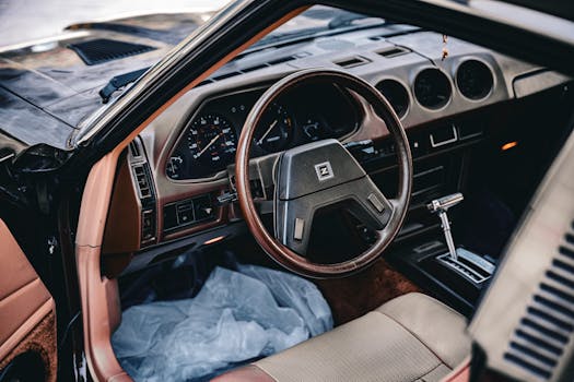 Explore the retro automotive design of a vintage car interior, featuring a classic dashboard and steering wheel.