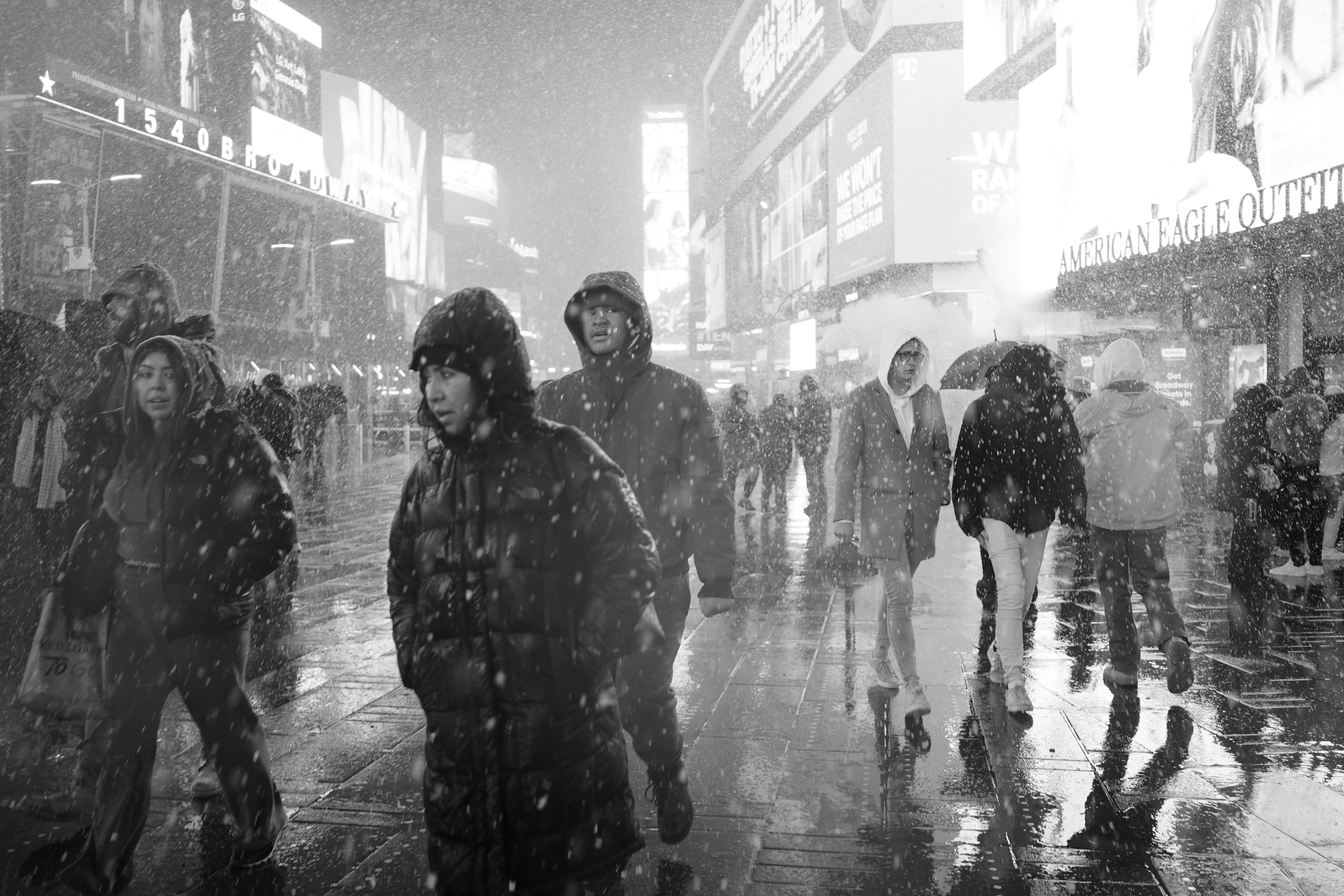 people walking in snow in city downtown