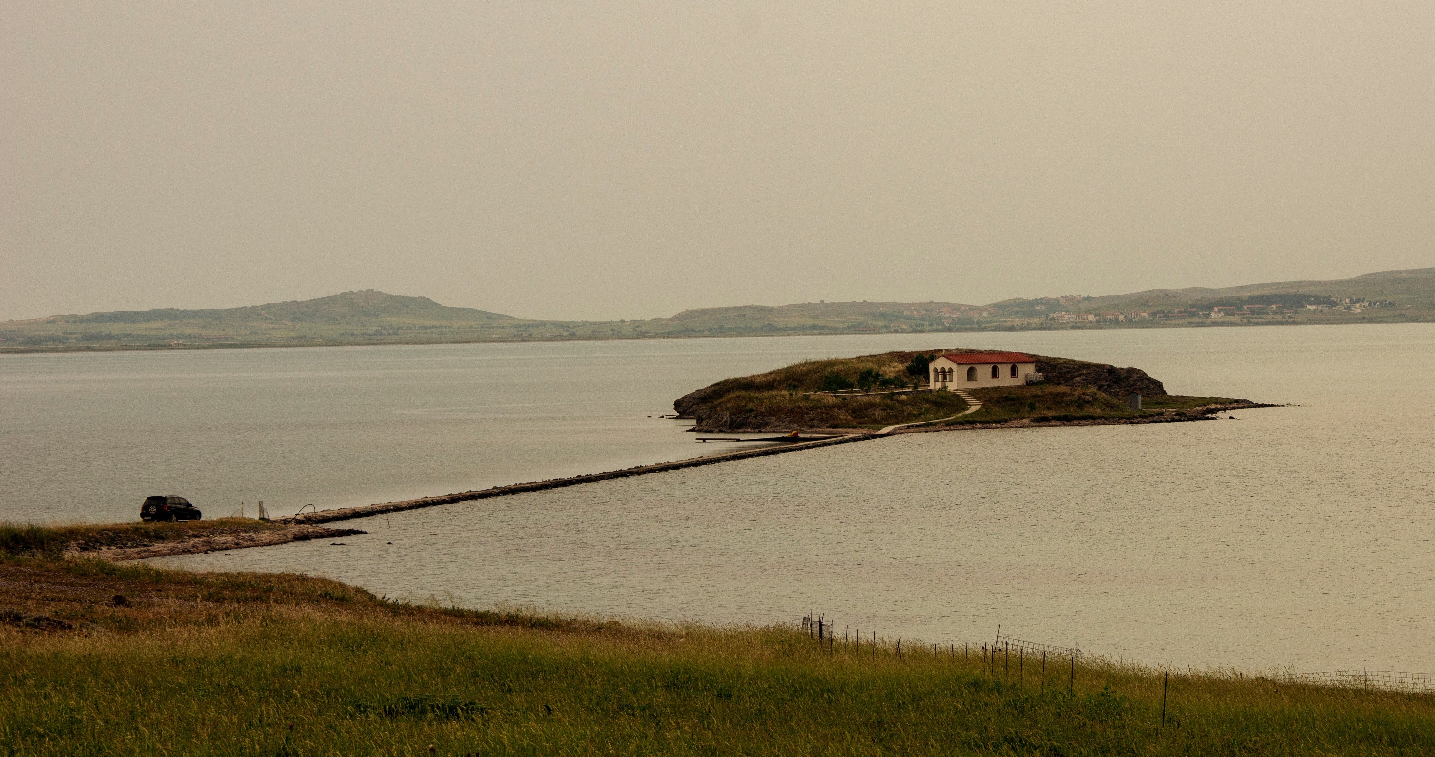 A quiet bay on Lemnos with a single building on the shore and calm water.