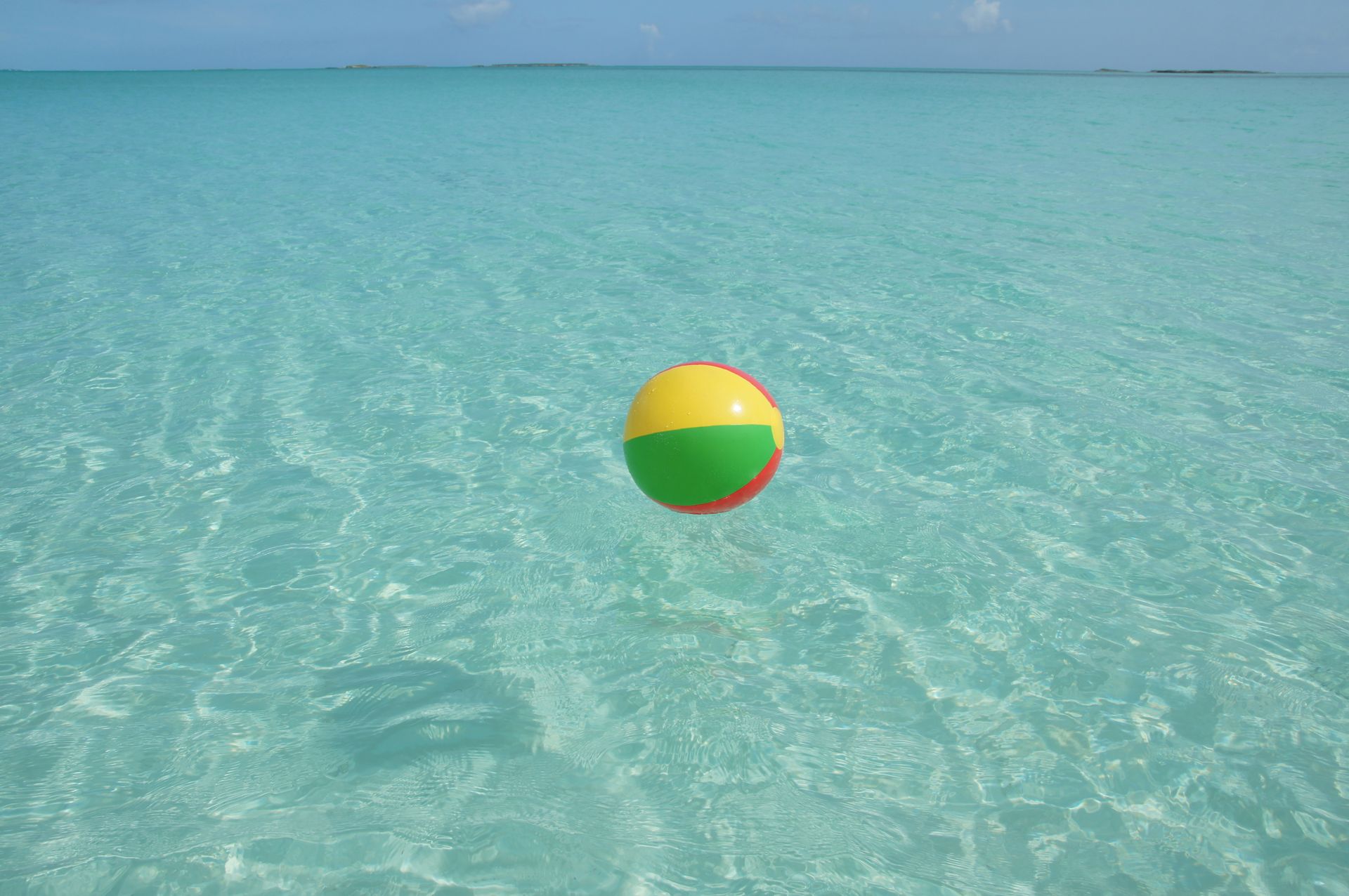 Vibrant beach ball floating on turquoise waters in George Town, Bahamas. Perfect for vacation vibes.