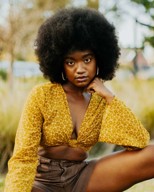 A young woman with an afro wearing a yellow top