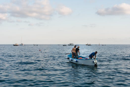 三名男子乘着一艘渔船，在蓝天下平静的水域中航行