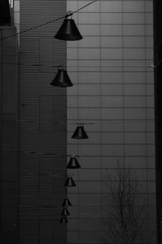 Vertical shot of streetlights against a monochrome urban facade in Dublin, Ireland.