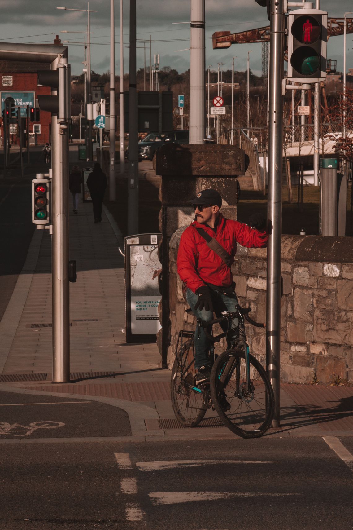 Cyclist waiting at a city crossing with a bicycle