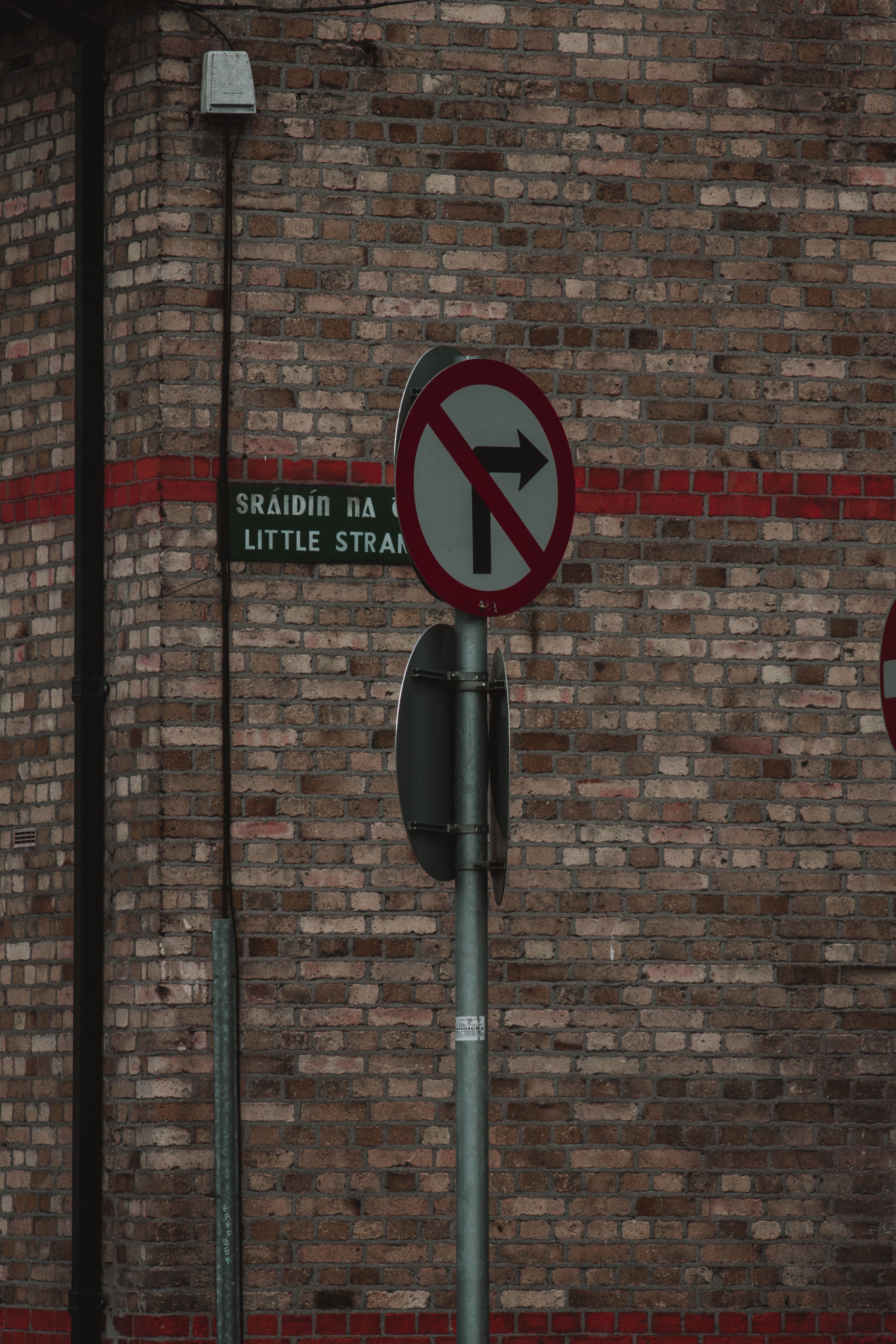 Close-up of 'No Right Turn' signs and Little Strand street sign in Dublin, Ireland.