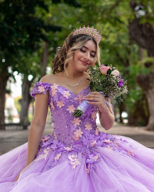 Young Woman in a Purple Dress with a Bouquet of Flowers 