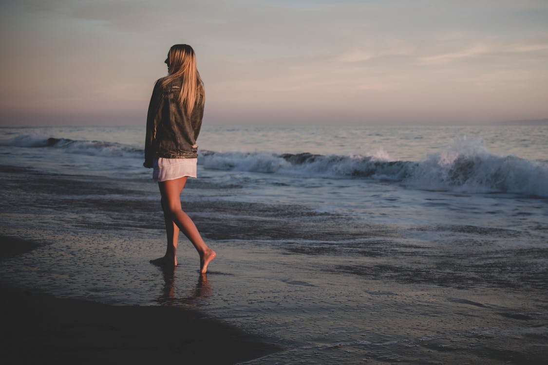 Free Woman Walking Beside Seashore Stock Photo