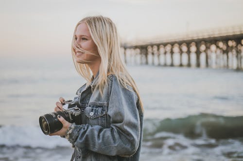 Free Woman Taking Pictures Beside Ocean Stock Photo