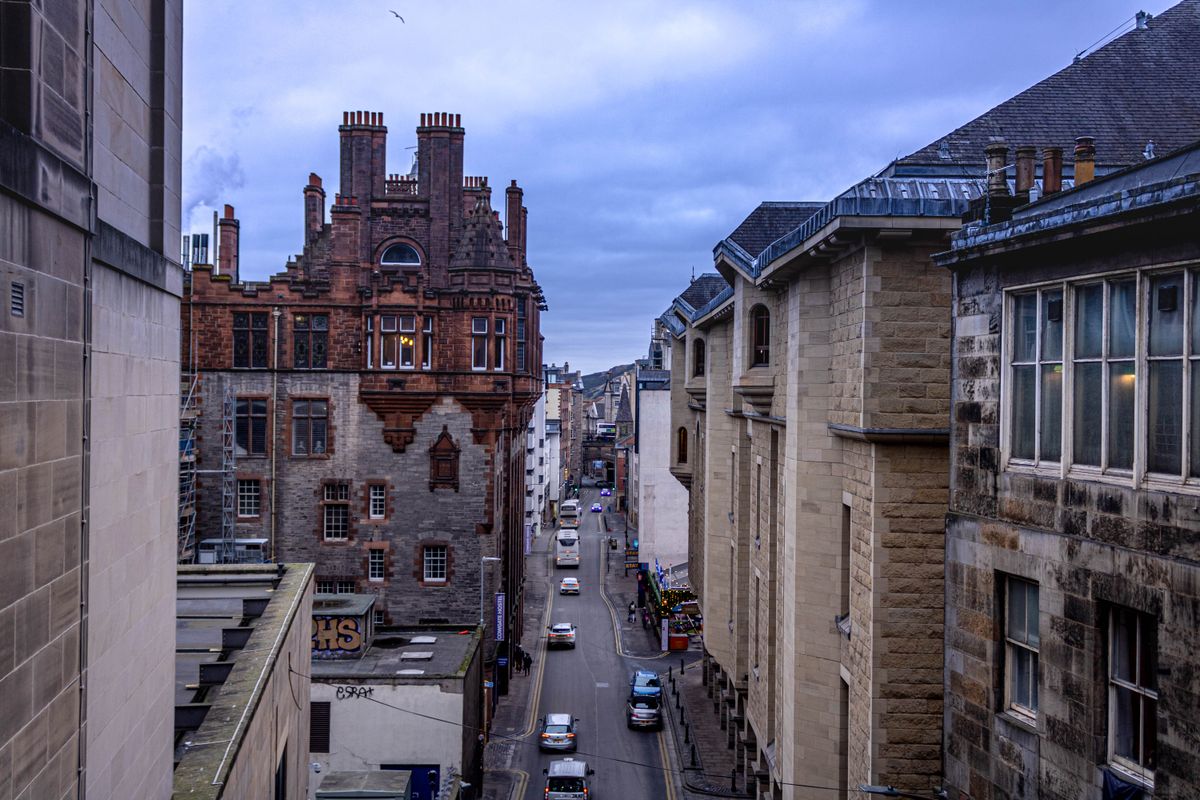 Narrow street in Edinburgh with historical buildings on an overcast day