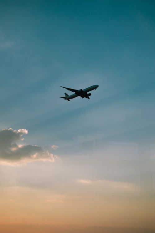 Free Silhouette of an airplane flying against a colorful sunset sky in Ciudad de México. Stock Photo