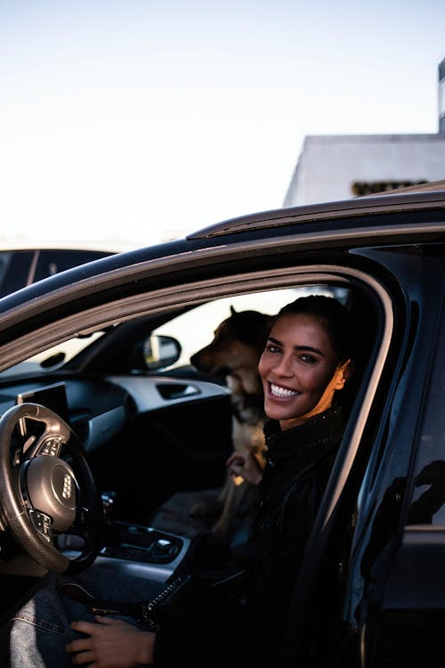 Smiling Woman in Car with Dog