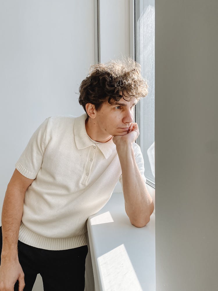 Young Man With Curly Hair Looking In Window