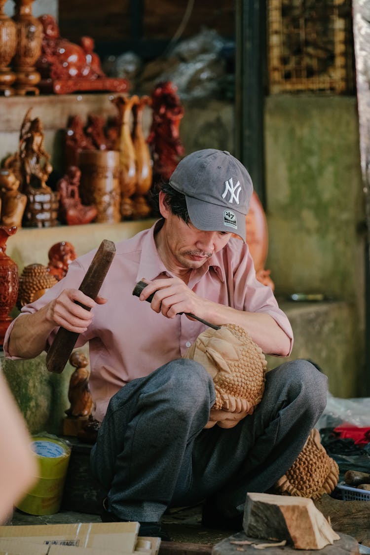 Man Carving On Wood With Tools