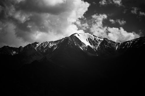 Free Stunning black and white view of snow-covered mountains under a cloudy sky in Kashmir. Stock Photo