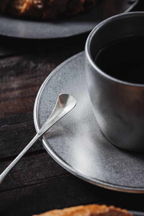 Silver Teaspoon and Coffee Cup on Table