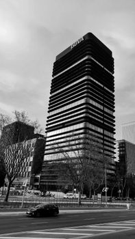 Black and white photo of a modern skyscraper in Madrid's financial district.