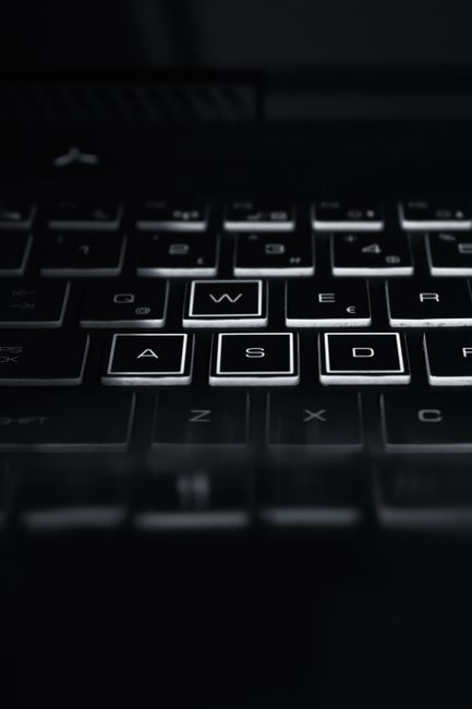 Fotomural Primer plano de un teclado retroiluminado de portátil destacando las teclas WASD. Perfecto para temas de tecnología.