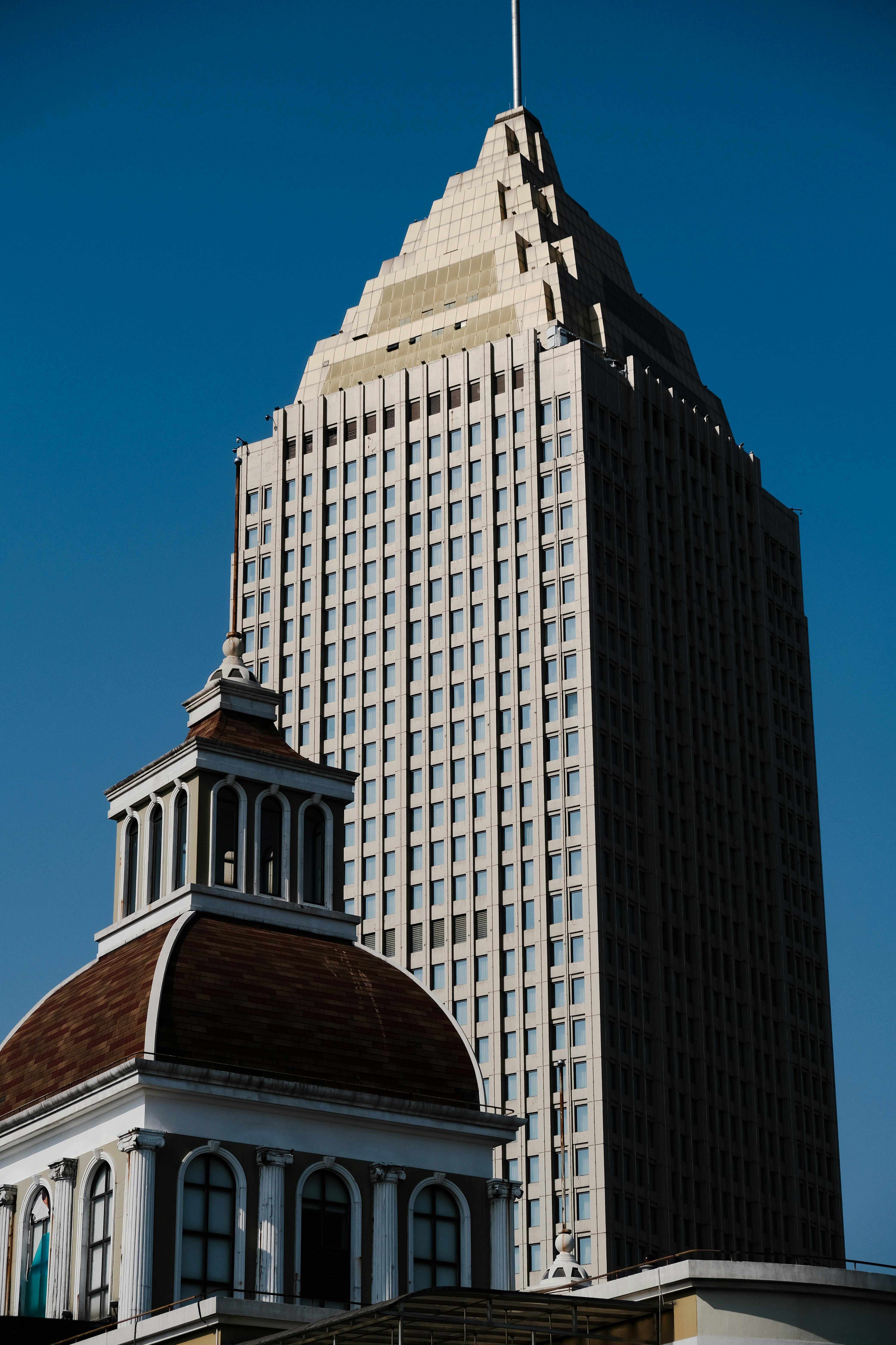 Tall skyscraper with distinctive architecture set against a clear blue sky, showcasing urban elegance.
