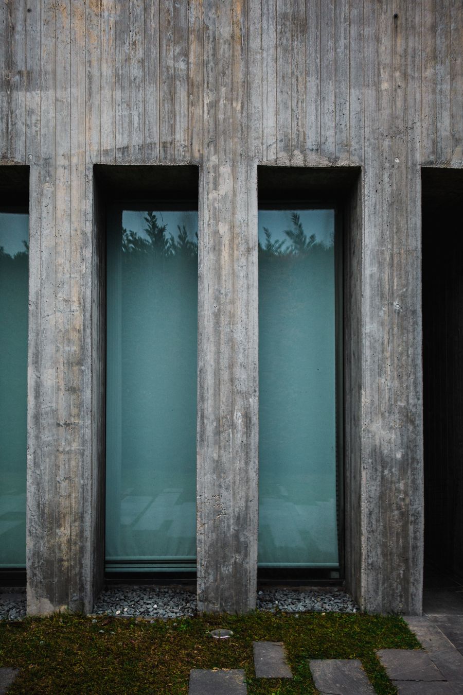 Pavilhão Cota: fachada de concreto com janelas verticais estreitas