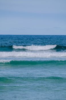 Captivating view of ocean waves under a clear blue sky, perfect for summer vibes.