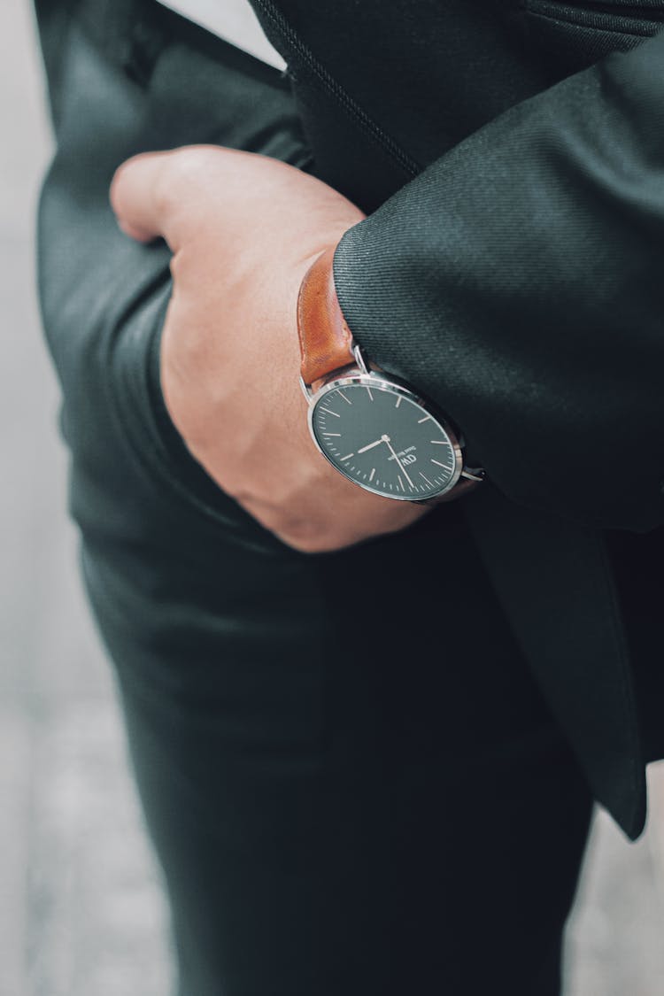 Daniel Wellington Classic St Mawes Watch With Brown Leather Strap On The Wrist Of A Model In A Suit