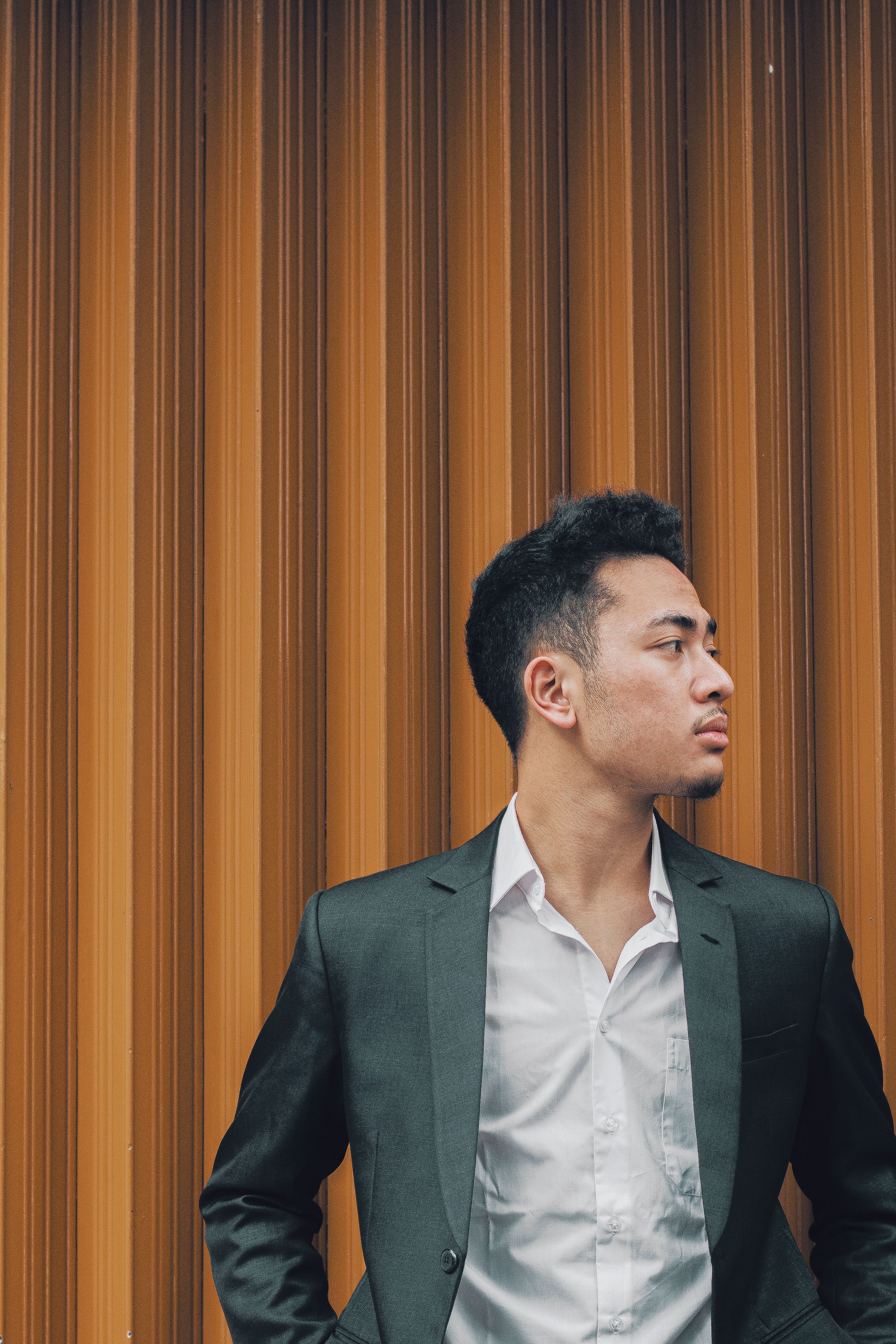 A man in a suit standing against a wall · Free Stock Photo