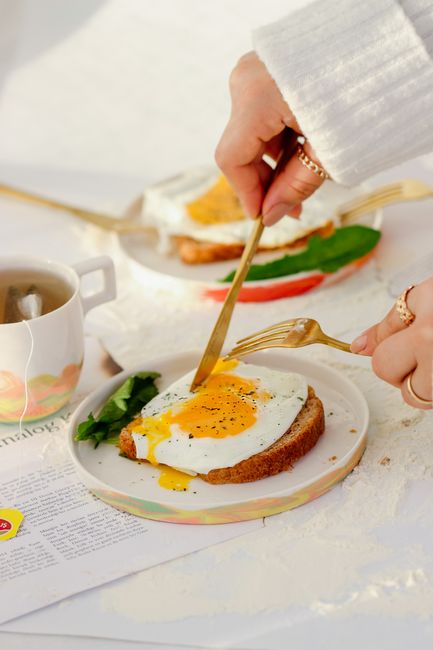 A delicious breakfast scene with a fried egg on toast served alongside tea.