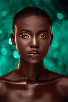 Elegant portrait of a model with short hair, against a vivid green backdrop.