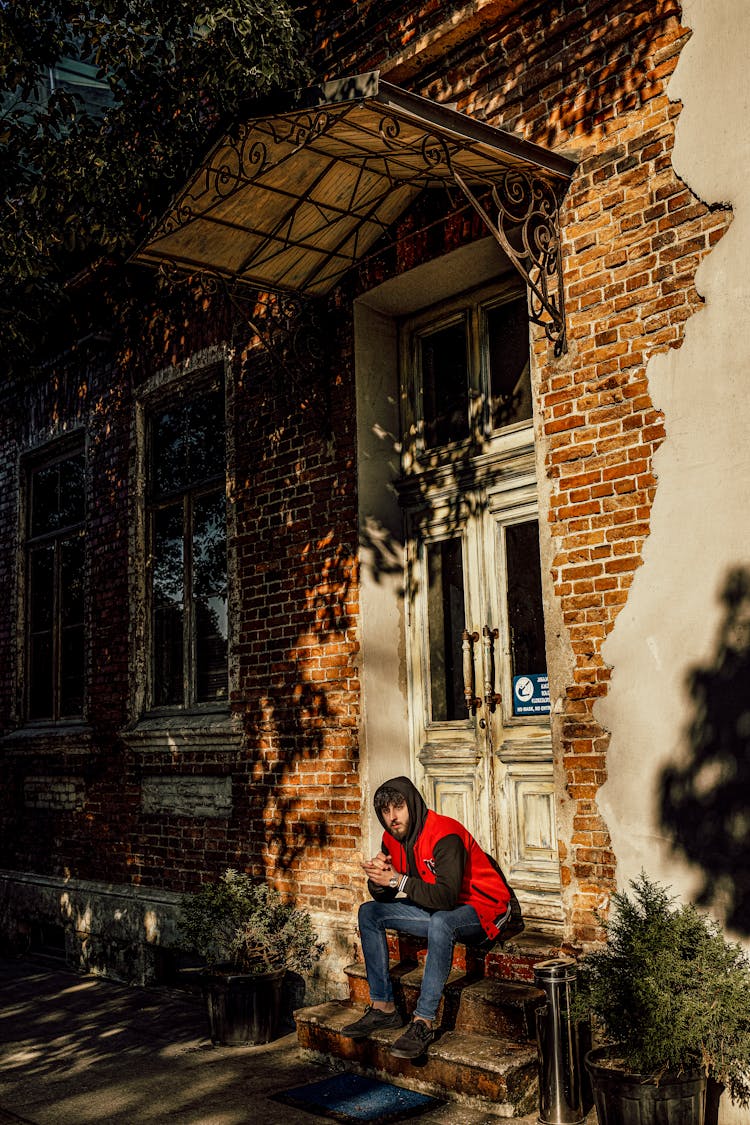 Man Sitting On A Front Stoop