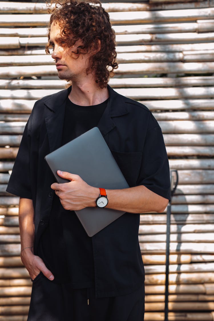 Standing Man Holding Laptop Under Arm