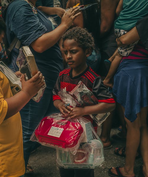A Boy in the Crowd Holding New Toys 