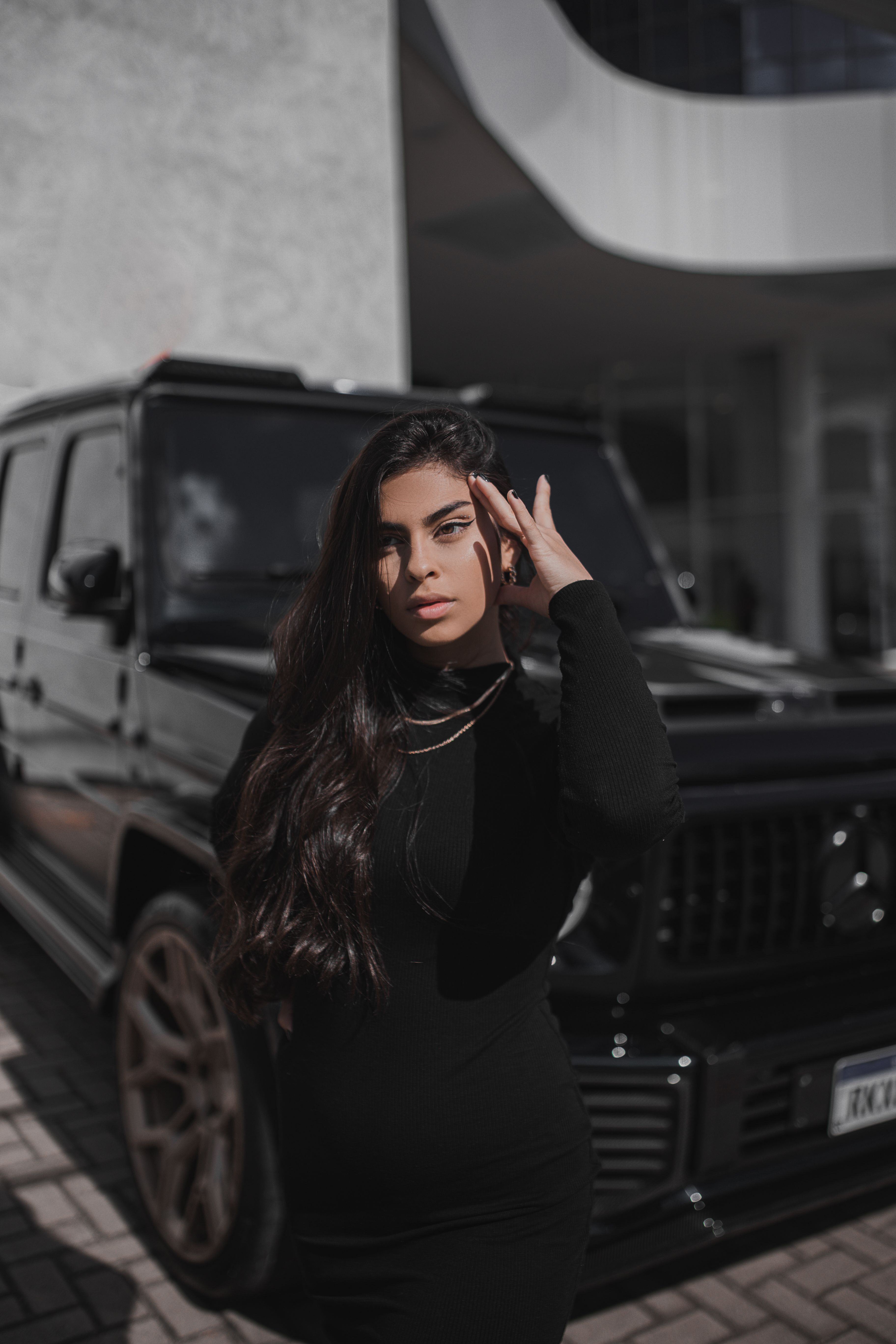 Young Brunette Standing in front of a Black Car · Free Stock Photo