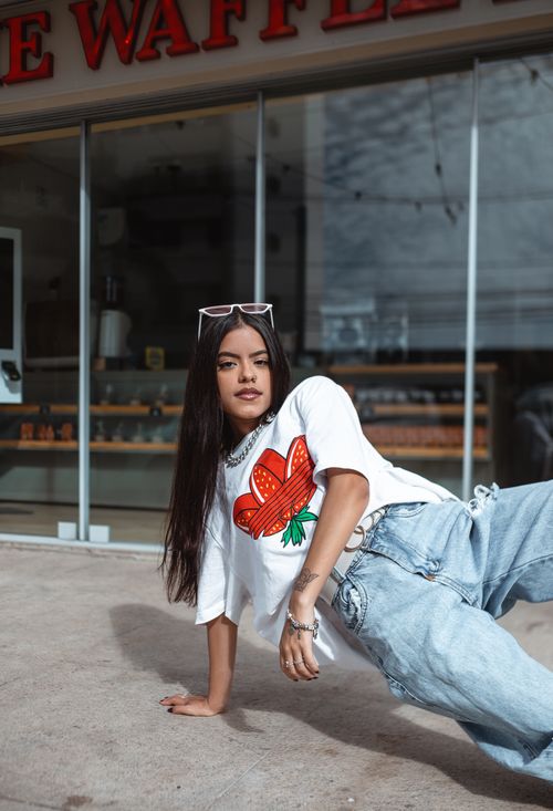 Free A stylish woman poses outdoors in a casual t-shirt and jeans, showcasing urban fashion. Stock Photo