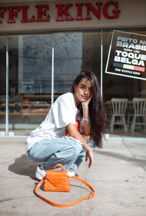 Woman Crouching by an Orange Purse